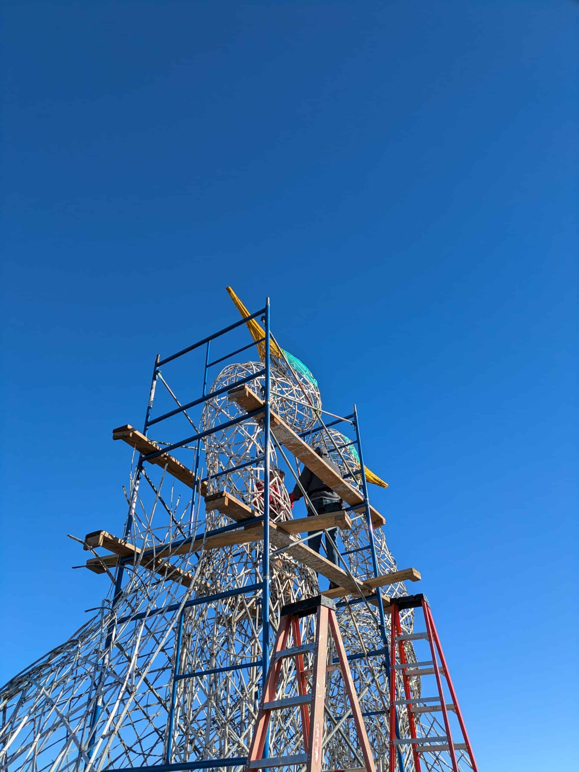 Artistic metal tower sculpture for public art displays under clear blue sky.