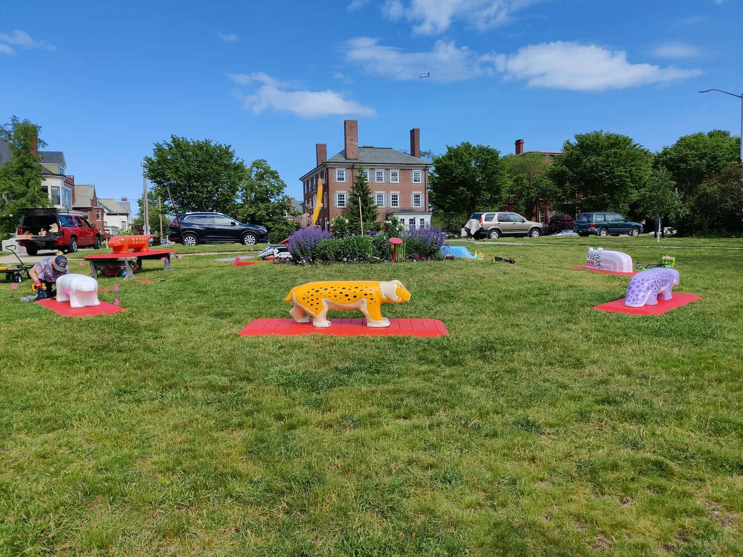 Colorful animal sculptures displayed outdoors on a lush green lawn, part of TEMPOart public art exhi.