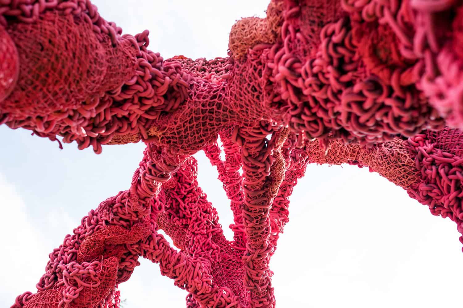 Abstract red sculpture with intricate textures and organic shapes.