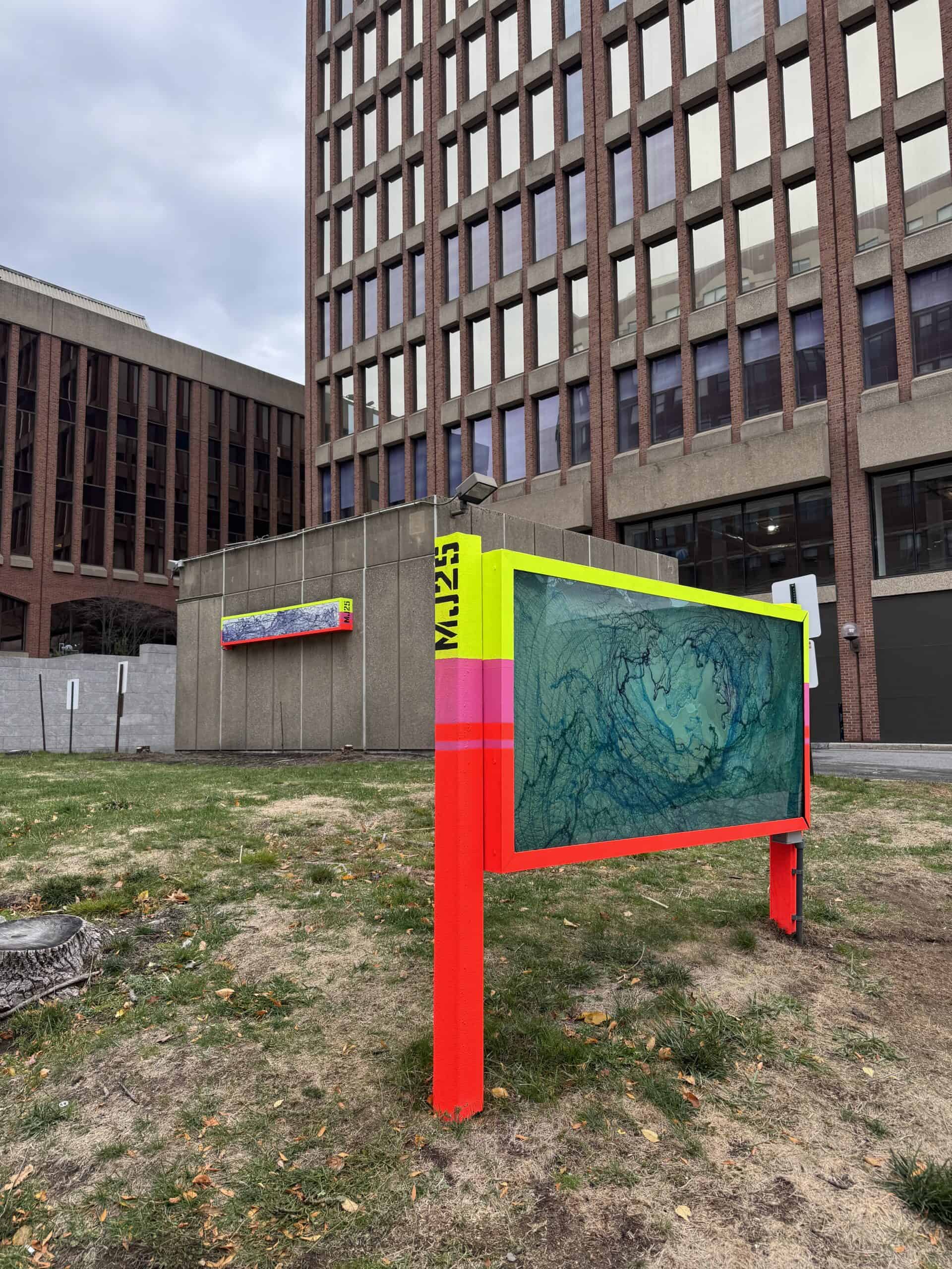 Colorful urban art installation with a large digital screen in front of a city building.