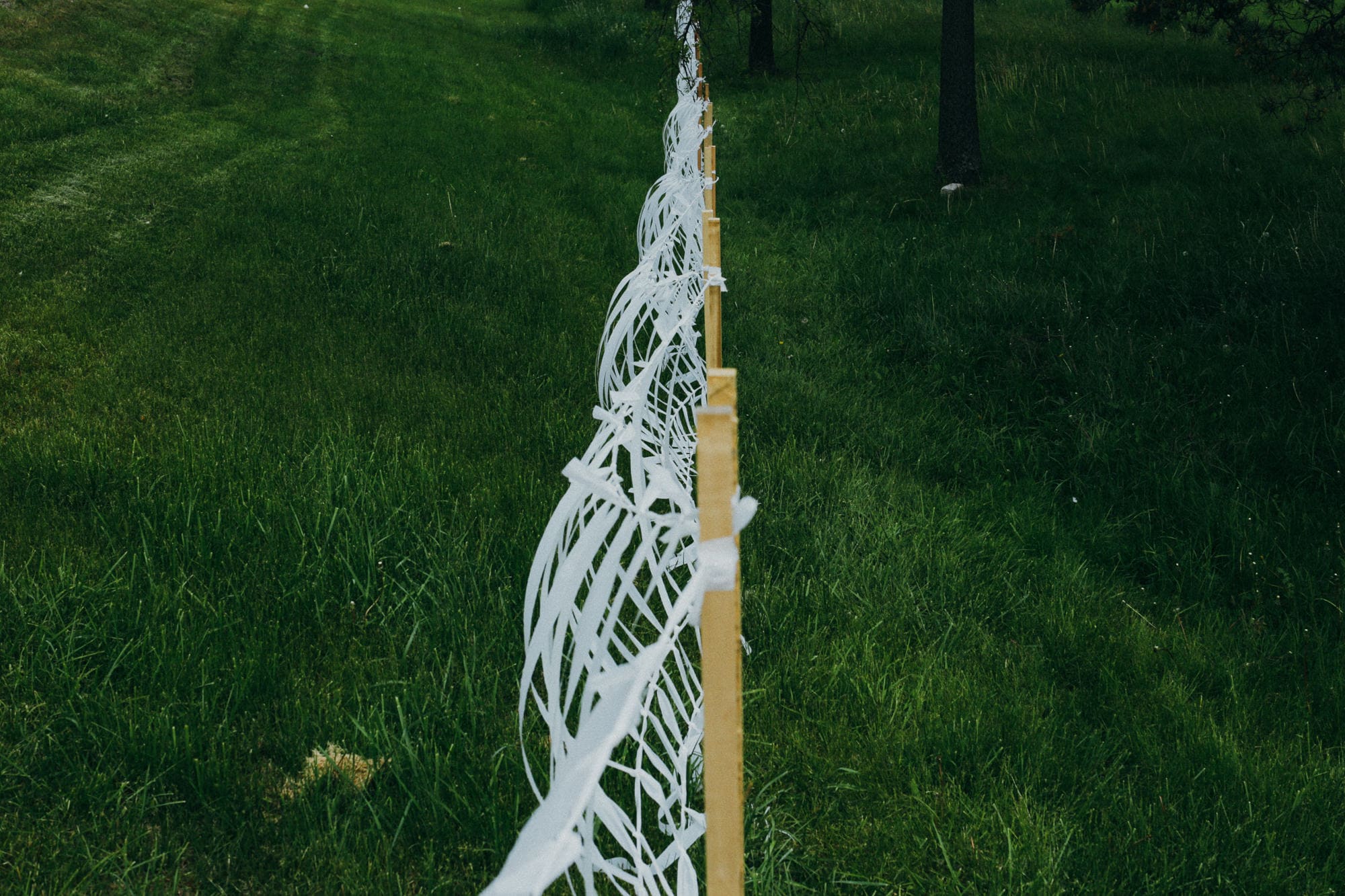 White abstract sculpture installation on green grass in outdoor park setting.