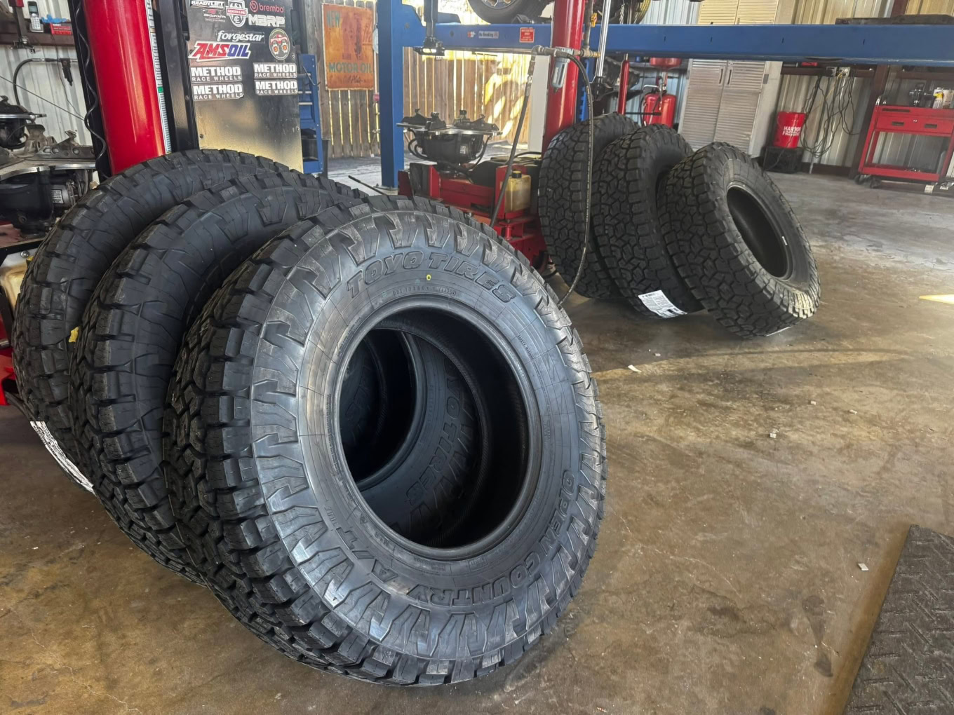 Large off-road tires displayed at Texas Tire LLC for vehicle servicing.
