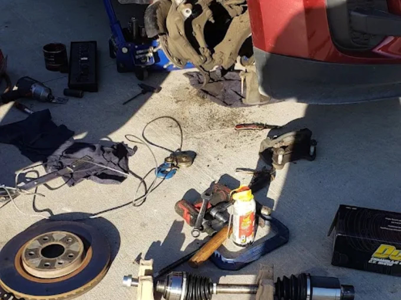 Auto repair scene with tire, brake components, and tools at Texas Automotive & Tire LLC.