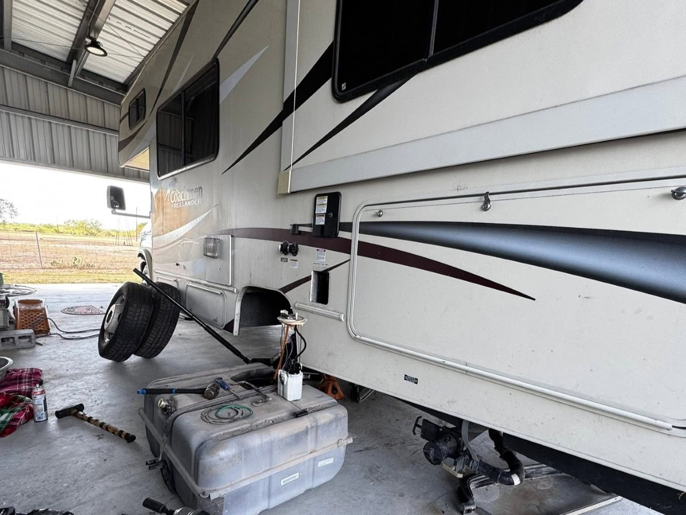 RV parked at Texas Automotive & Tire LLC with tire and tools nearby.
