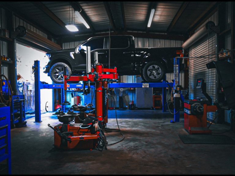 Inside view of a vehicle lift and tire equipment at Texas Automotive & Tire LLC.