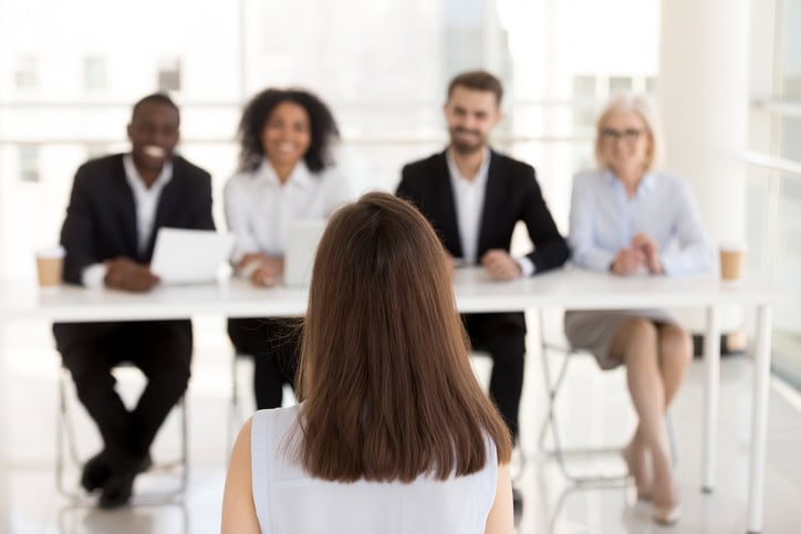 Nonprofit executive interview with diverse hiring panel meeting candidate in welcoming office environment