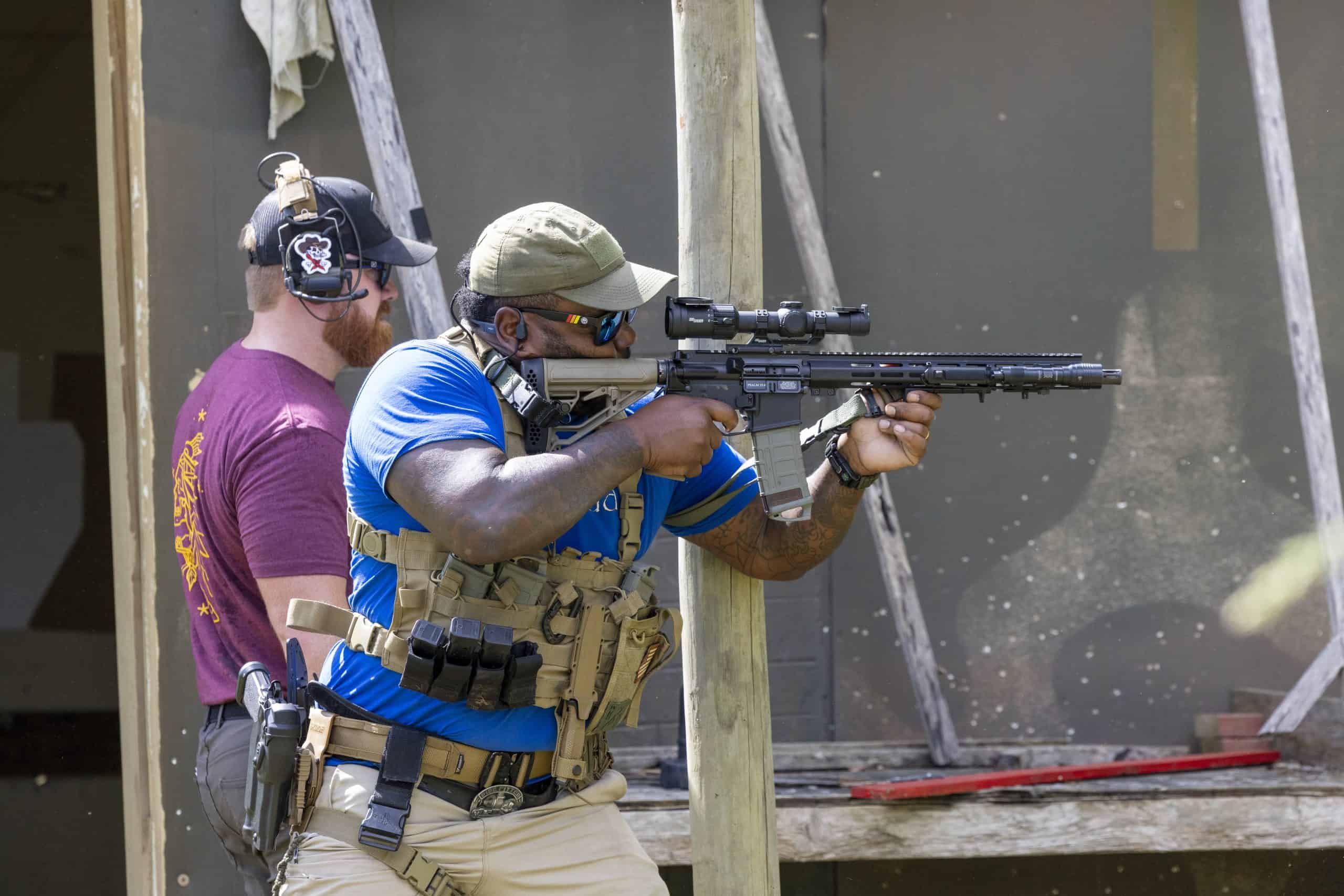Competitor shooting aiming down an LPVO mounted on an AR-15 at a 2 Gun competition hosted by Osprey Training Facility