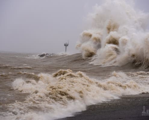 Wild stormy sea waves crashing during severe weather event.