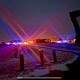 Colorful emergency lights at night in Fostoria, Ohio, with a snowy landscape and police vehicles.