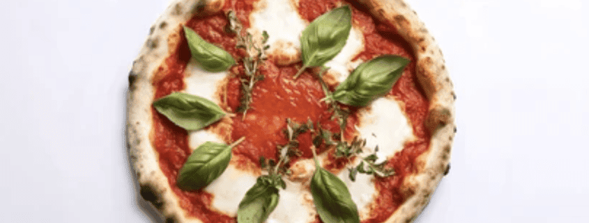 Delicious Margherita pizza topped with basil leaves, mozzarella, and fresh tomato sauce, ideal for food lovers.