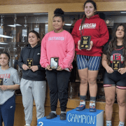 Young female athletes showcasing wrestling achievements at The Fostoria Free Press.