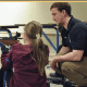 Young girl practicing rifle shooting with instructor.