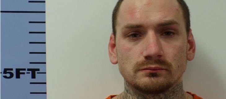 1. Mugshot of young man with neck tattoos and short hair, orange prison jumpsuit.