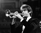 Jazz musician playing trumpet in a concert setting.
