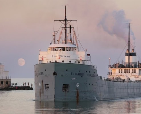 Old steamship docked at harbor during sunset, Fostoria Free Press local news coverage.