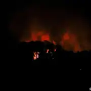 Fire burning in the night sky with smoke, news coverage by The Fostoria Free Press.