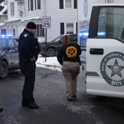 Police officers investigating crime scene with law enforcement vehicles in Fostoria Ohio.