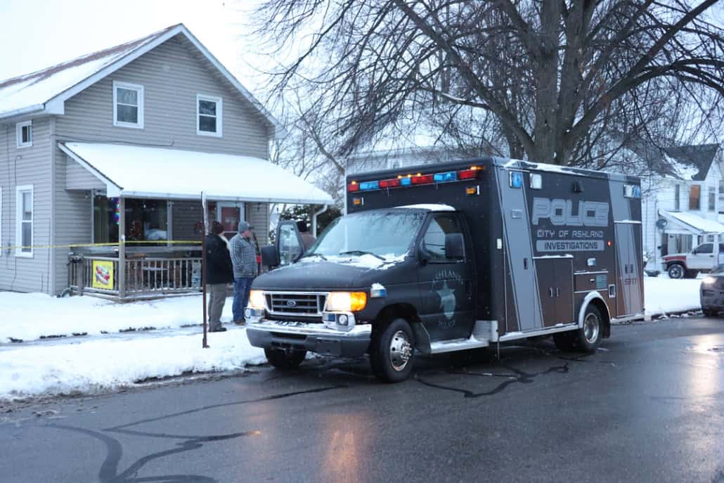 Police investigation scene in Fostoria during winter snow.