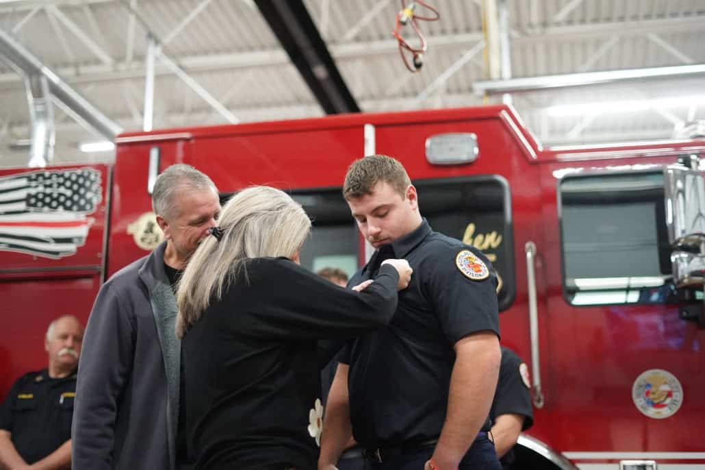 Heroic firefighter receiving recognition during community event at Fostoria Fire Department.