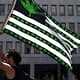 Marijuana flag with cannabis leaf and stripes, urban background.