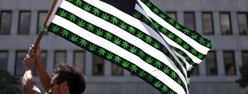 Marijuana flag with cannabis leaf and stripes, urban background.