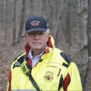 Fostoria News Hamilton Fire Department official in a high-visibility jacket and hat in a forest setting.