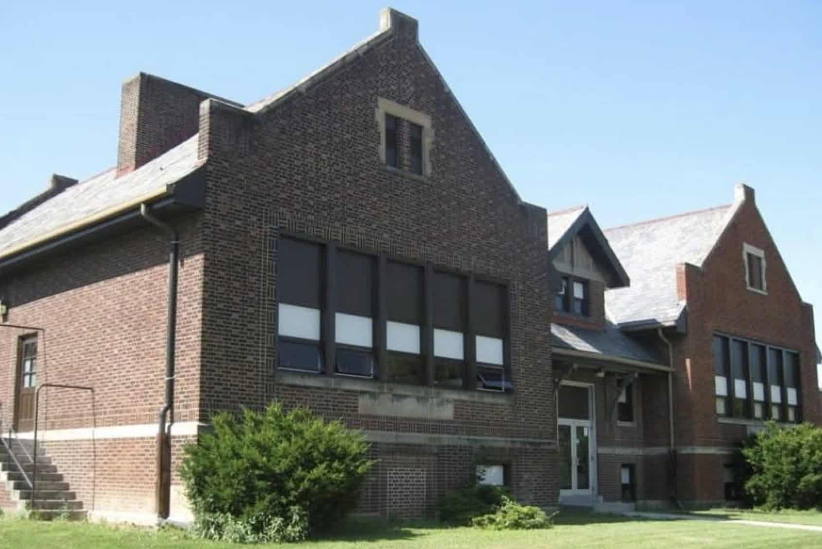 Fostoria News Historic brick school building in Fostoria with large windows and greenery.