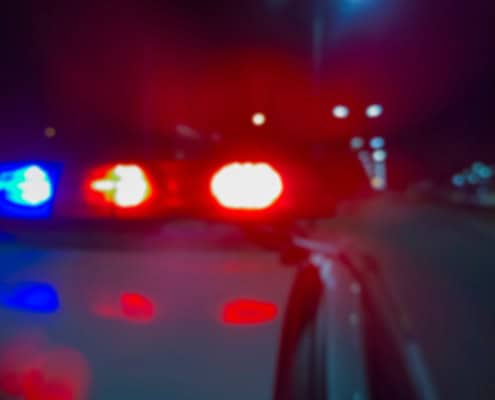 Blurred police car lights at night, emergency response, local news, Fostoria Ohio.