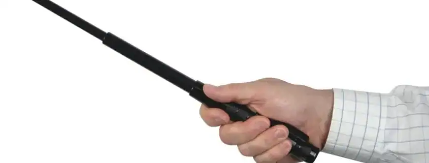 Wireless police baton communication device in hand for security and law enforcement.