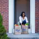 Fresh groceries from Kroger delivered to a happy woman at her doorstep.