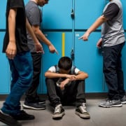 Bullying in school locker room, peer harassment, student conflict, school safety issues, mental health awareness.