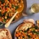 Fresh homemade vegetable soup served with bread on a table.