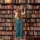A woman browsing books in a library at The Fostoria Free Press office.