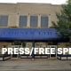 Fostoria News Fostoria Corner Ltd. storefront with blue awning and outdoor seating area.