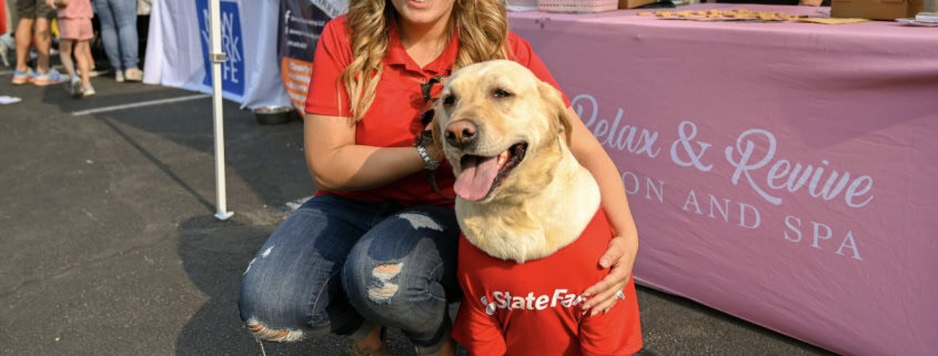 Fostoria News Woman with dog at outdoor event during Downtown Tiffin Third Thursdays.