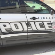 Police car parked on the street with "FINDLAY POLICE" branding and badge logo visible.