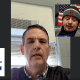 Fostoria News Two men in a video call, one in front of a window and the other with an American flag background.