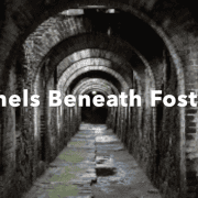 Historic brick tunnels beneath Fostoria with arched ceilings and mossy floors.