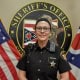Sheriff's officer in front of sheriff's office seal with American and Ohio flags.
