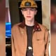 Young man wearing a tan jacket with patches and pins at The Fostoria Free Press event.