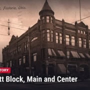 Fostoria News: Early 1900s postcard of the Alcott Block, a three-story brick building with a corner turret at Main and Center streets in Fostoria, Ohio