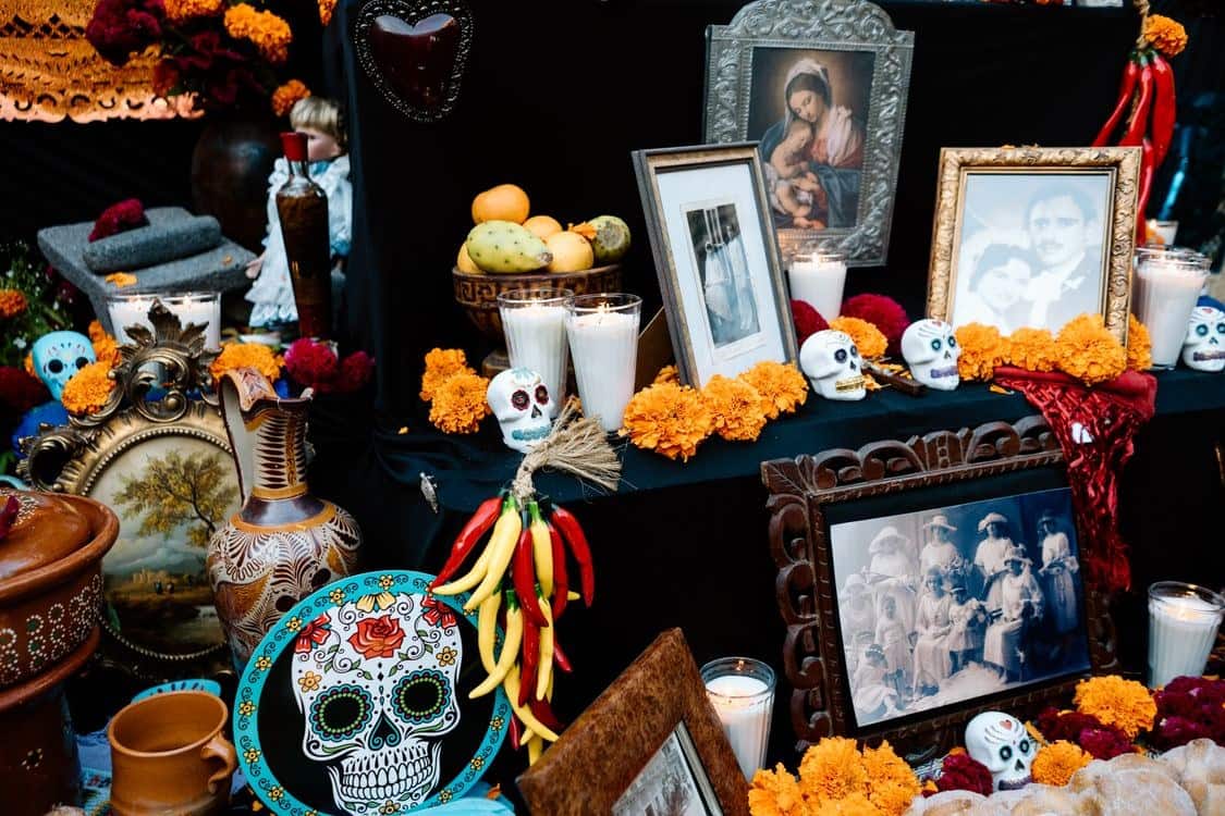 Fostoria News: An ofrenda with orange marigolds, sugar skulls, candles and framed family photos