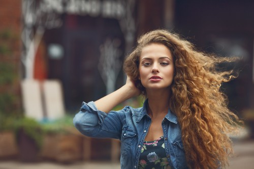 Woman with defined 2B S-shaped waves with flat roots and visible frizz.