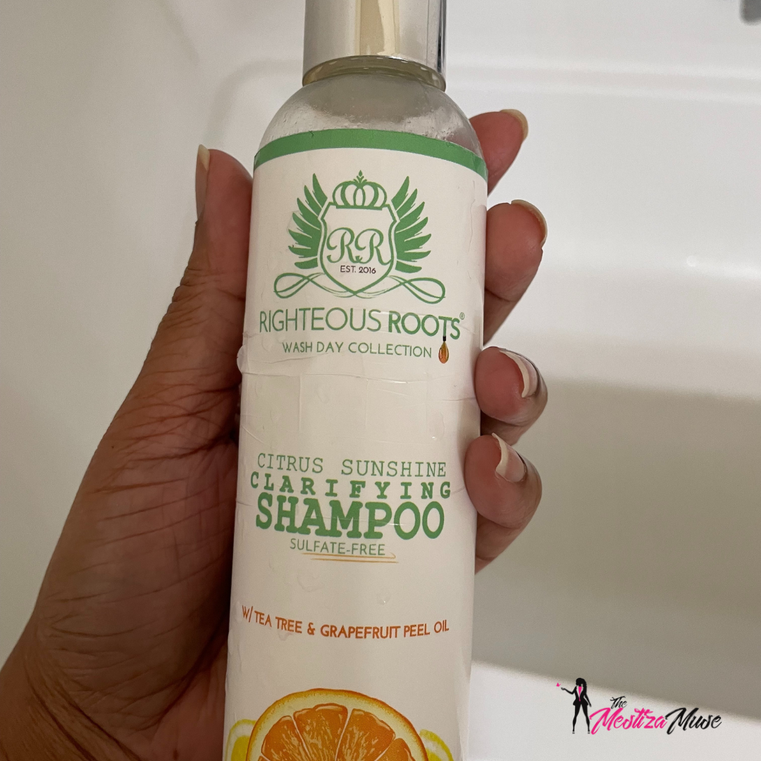 Author's hand holding a bottle of Righteous Roots Clarifying Shampoo.