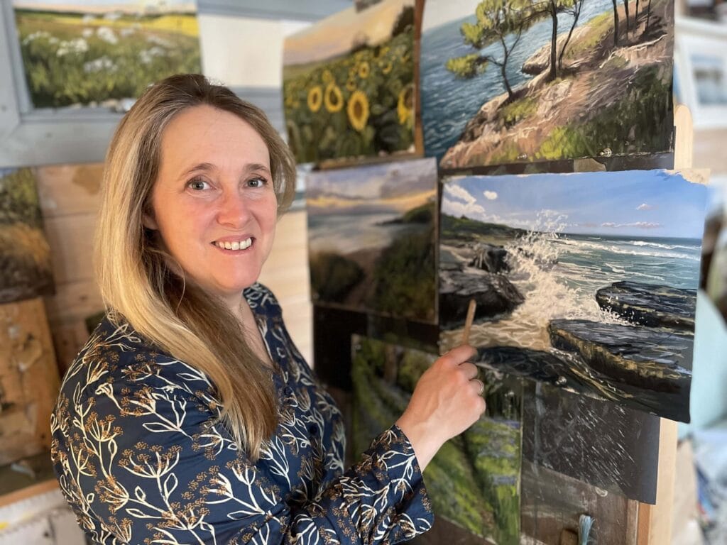 Nina Squire painting coastal landscape on canvas at her studio.