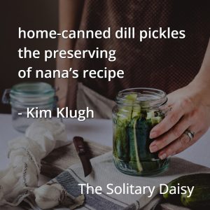 A person holding a jar of pickles on a table with a towel, knife, and an empty jar; text about home-canned dill pickles and preserving a family recipe overlays the image, celebrating the joy of homemade food.