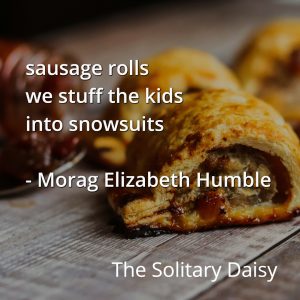 Close-up of baked sausage rolls on a wooden surface, capturing the warmth of food, with text overlay quoting a poem by Morag Elizabeth Humble and the title "The Solitary Daisy.