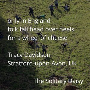 People roll down a steep grassy hill chasing a cheese wheel, capturing the unique sense of place at this event in Stratford-upon-Avon, UK. White text overlay highlights the excitement and charm of this quirky local tradition.