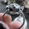 Front view of the rounded Budgett's frog perched over a sterling silver ring band