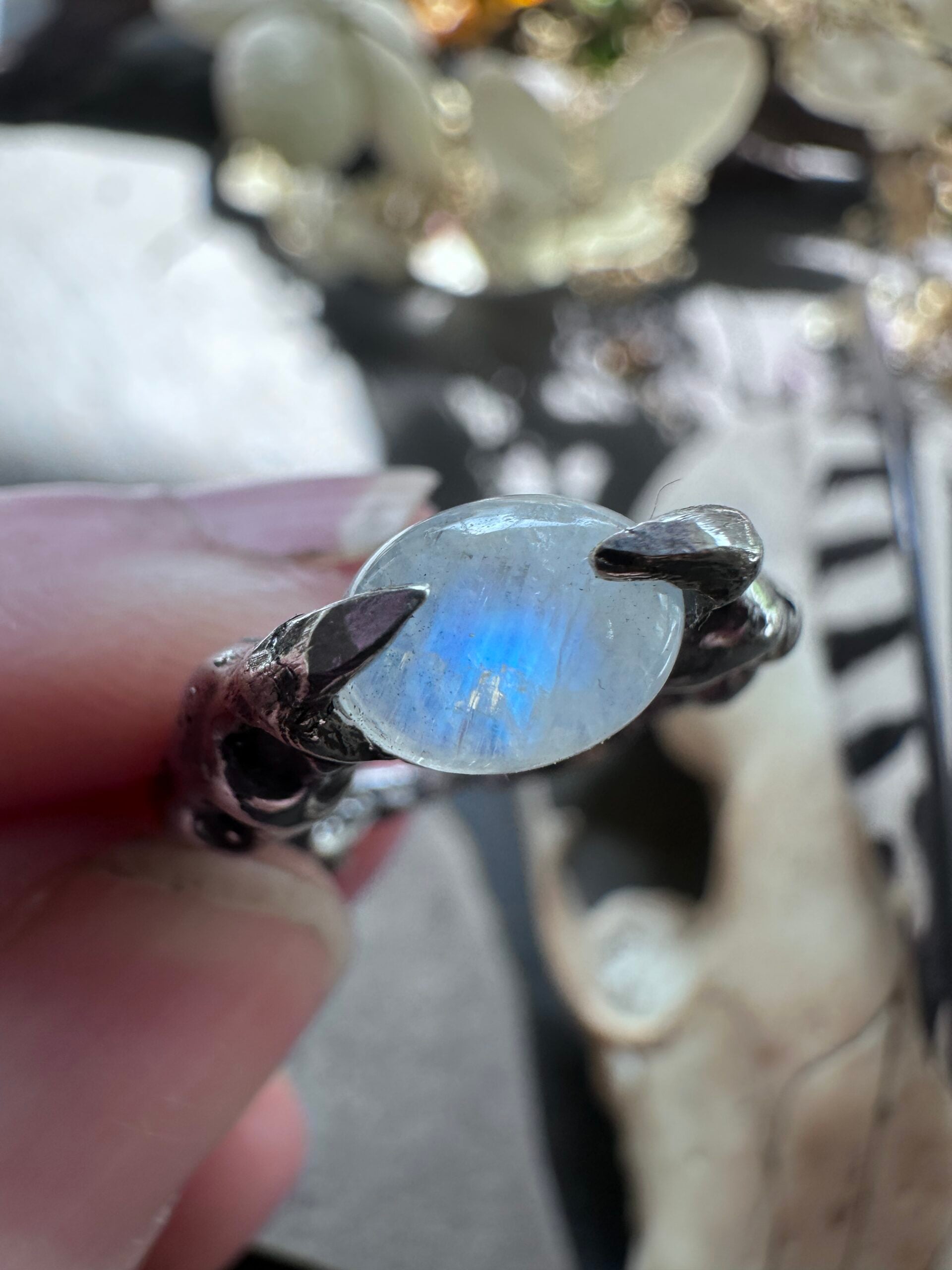 Blue flash in a rainbow moonstone held by sterling silver claws, US ring size 7